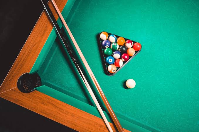 Racked pool balls and cues on a professional table